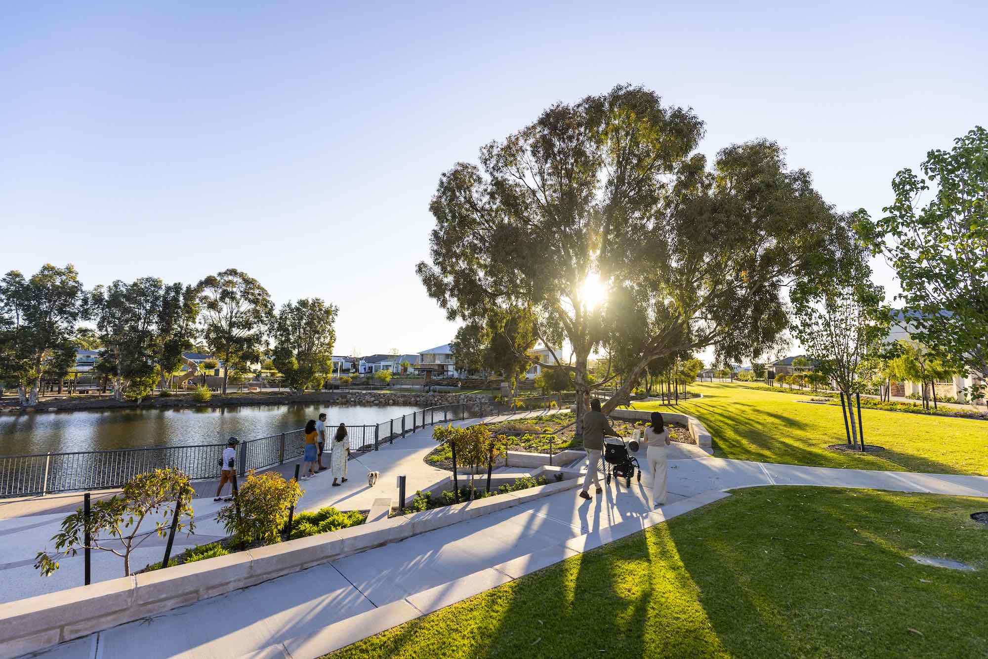 lake treeby land for sale estate multicultural people walking by lake into sun 